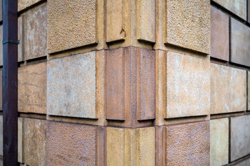 Closeup Background of Red, Yellow, and Tan Blocks in a Corner Wall.