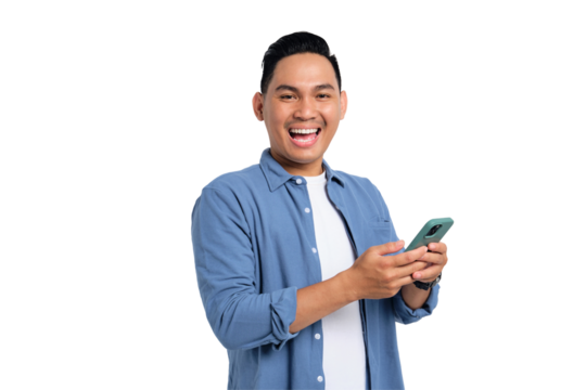 Smiling young Asian man in casual shirt using smartphone, chatting online, texting message, looking at camera isolated on transparent background