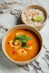 Bright shrimp curry features vibrant colors and herbs, paired with fluffy rice and a lime wedge