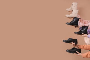 Female hands with different boots on beige background