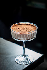 A creamy dessert is beautifully presented in an elegant glass, inviting indulgence and enjoyment