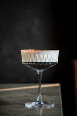 A rich dessert cocktail with a creamy top and dark layers offers elegant presentation