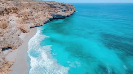 Rugged coastline meets turquoise sea, creating stunning beach scene with gentle waves