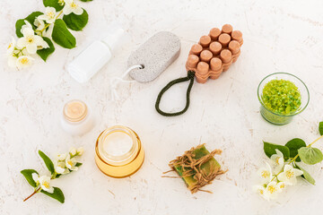 Body care products and branches of jasmine on the white background.