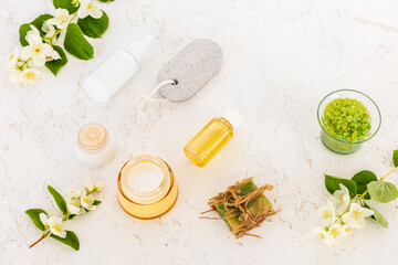 Body care products and branches of jasmine on the white background.
