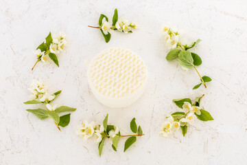 Body care products and branches of jasmine on the white background.