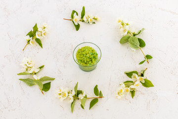 Body care products and branches of jasmine on the white background.