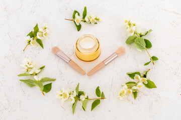 Body care products and branches of jasmine on the white background.