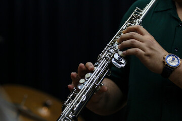 Close-Up of Musician Playing saxophone or flute in Studio with black solid background