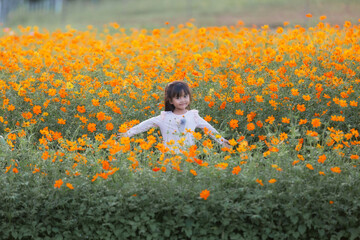 The children girl of vast flower field in full bloom stretches.