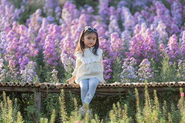 The children girl of vast flower field in full bloom stretches.