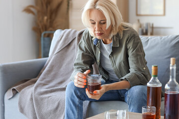 Drunk mature woman at home. Concept of alcoholism