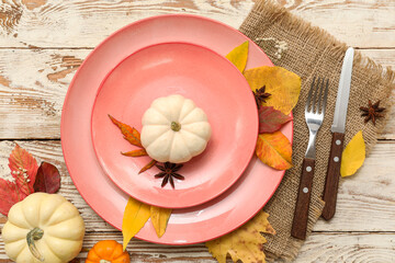 Beautiful table setting with fresh pumpkins, star anise, gypsophila flowers and autumn leaves on...