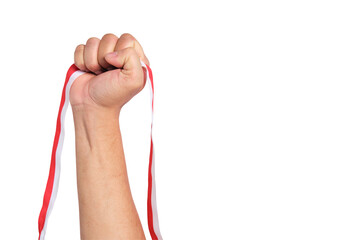 Human hand holding a red and white ribbon as a symbol of the Indonesian flag isolated on...