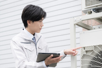 室外機の点検をする作業員　指を差して安全確認