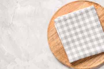 Wooden plate with napkin on white grunge table, top view
