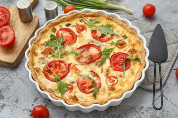 Delicious tomato tart with arugula leaves and green onion on grey background, closeup