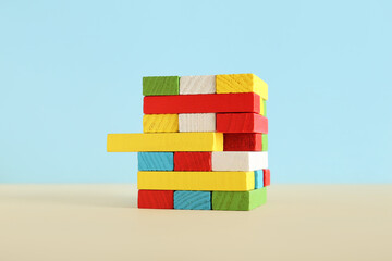Tower of colorful blocks on table near blue wall. Logic concept