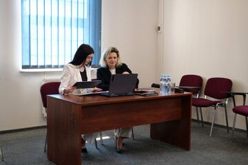 Two women meet to discuss a project and sign a contract.
