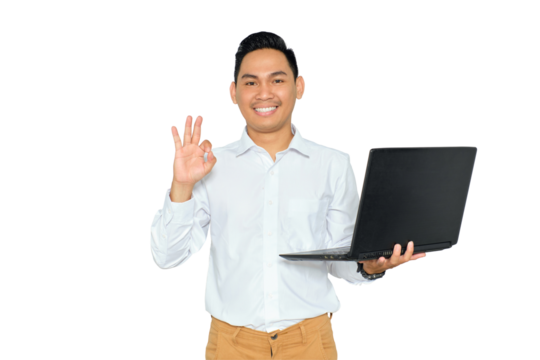 Portrait of happy young Asian man in formal wear holding laptop and showing ok sign, looking at camera with smile isolated on transparent background - Powered by Adobe