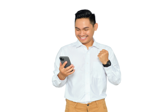 Happy young Asian man in formal wear using mobile phone for trading or chatting and making winning gesture isolated on transparent background
