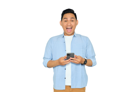 Excited young Asian man in casual clothes holding mobile phone and looking at camera with shocked expression isolated on transparent background