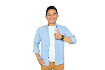 Portrait of happy young Asian man in casual clothes gesturing thumbs up, looking at camera with...