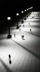 Obraz premium Nighttime Plaza: Silhouettes of People Under Streetlights