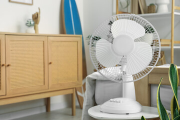 Modern electric fan on table in stylish bedroom, closeup