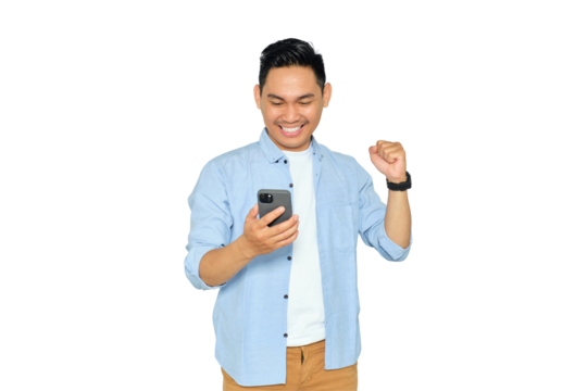 Happy young Asian man in casual clothes using mobile phone for trading or chatting and making winning gesture isolated on transparent background