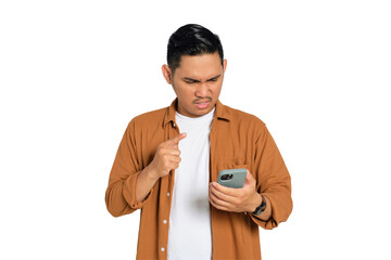 Angry young Asian man in casual shirt pointing with finger at his smartphone isolated on...