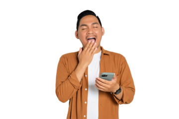 Portrait of sleepy Asian young man in casual shirt holding smartphone while yawning isolated on transparent background