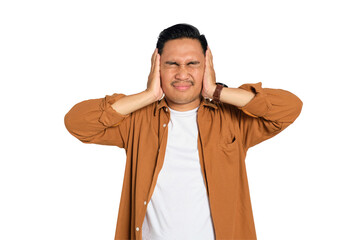 Irritated young Asian man in casual shirt covering his ears with hands, disturbed by loud noise...