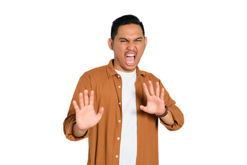 Say no. Annoyed young Asian man in casual shirt making stop gesture with hand isolated on...