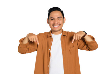 Happy young Asian man in casual shirt pointing finger down and smiling at camera isolated on transparent background © Khoirul Mahmudin