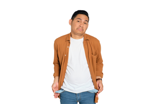 No money. Sad young Asian man in casual shirt showing his empty pockets, having financial problems isolated on transparent background - Powered by Adobe
