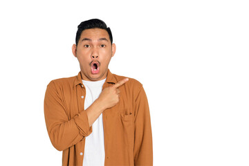 Excited young Asian man in casual shirt pointing finger at copy space, presenting sale offer...