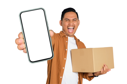 Happy young Asian man in casual shirt holding smartphone with blank screen and cardboard box isolated on transparent background