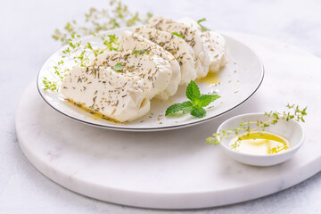 Raw halloumi, Cyprus squeaky cheese with herbs and olive oil prepared for grill