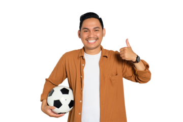 Happy young Asian man in casual shirt holding soccer ball and smiling, showing thumb up isolated on transparent background