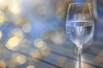 a glass of white wine, a background under the summer sun, a bokeh and sun glare, a blurred abstract background