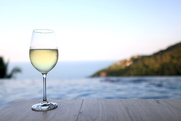 glass of cold white wine on the summer seashore by the water, relaxing by the water, a gentle background of soft color