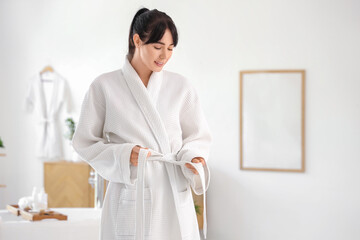 Young woman in waffle robe at home