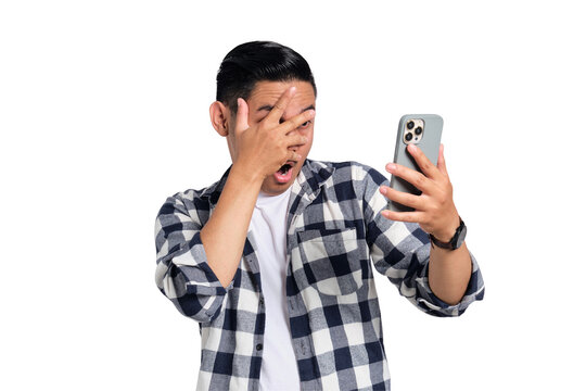 Scared young Asian man in casual shirt looking at mobile phone screen isolated on transparent background