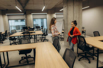 Two Women Discussing in a Modern and Bright Office Environment