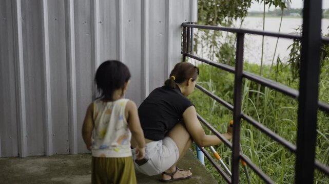 Toddler And His Mother Are Helping To Cut Weeds, Video footage for documentary film and cinematic in lifestyle scene.