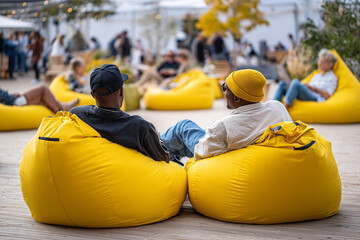 Friends relaxing on bean bags at an outdoor creative workshop, 