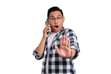 Surprised young Asian man in casual shirt talking on smartphone and making stop sign with hand isolated on transparent background