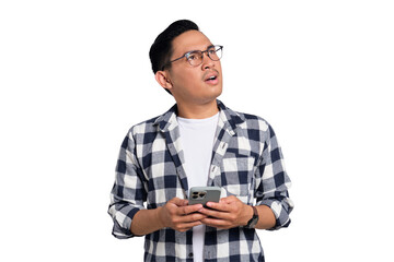 Doubtful young Asian man in casual shirt holding smartphone, looking aside at free space, thinking...