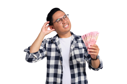 Financial planning. Pensive young Asian man in casual shirt holding money and looking up, thinking about question isolated on transparent background
